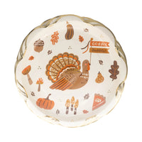 Round scalloped plate with turkey, pumpkins, leaves, mushrooms, and gold-foil rim.