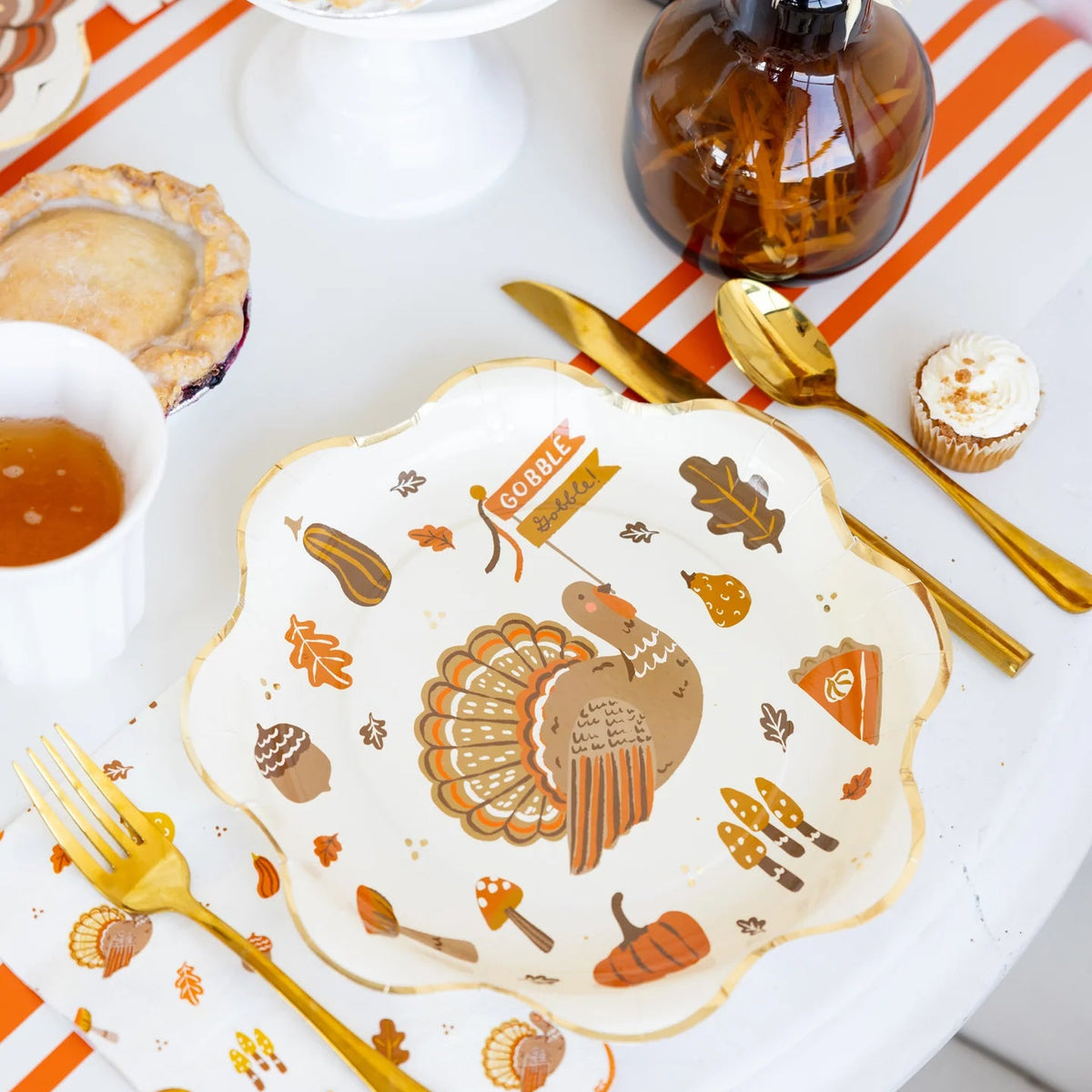 Close-up tablescape featuring icons plate with “Gobble” banner turkey artwork.