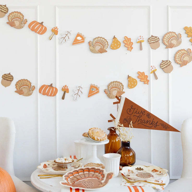 Icons banner strung above a fall tablescape with pies and coordinating tableware.