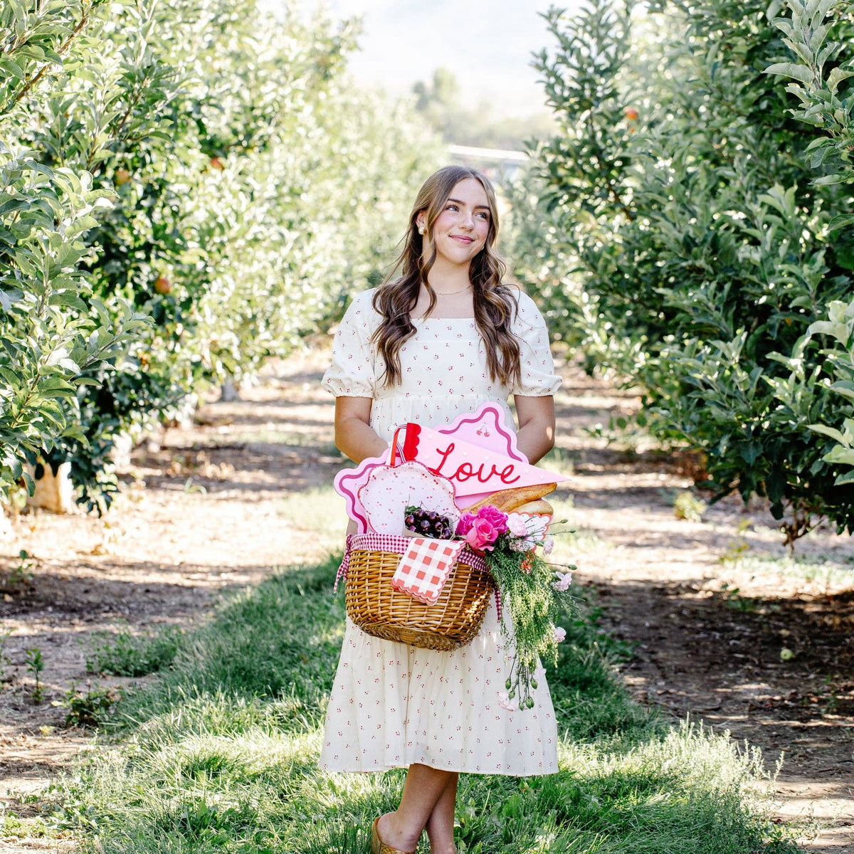 woman holding picnic basket with cherry plates and flowers
