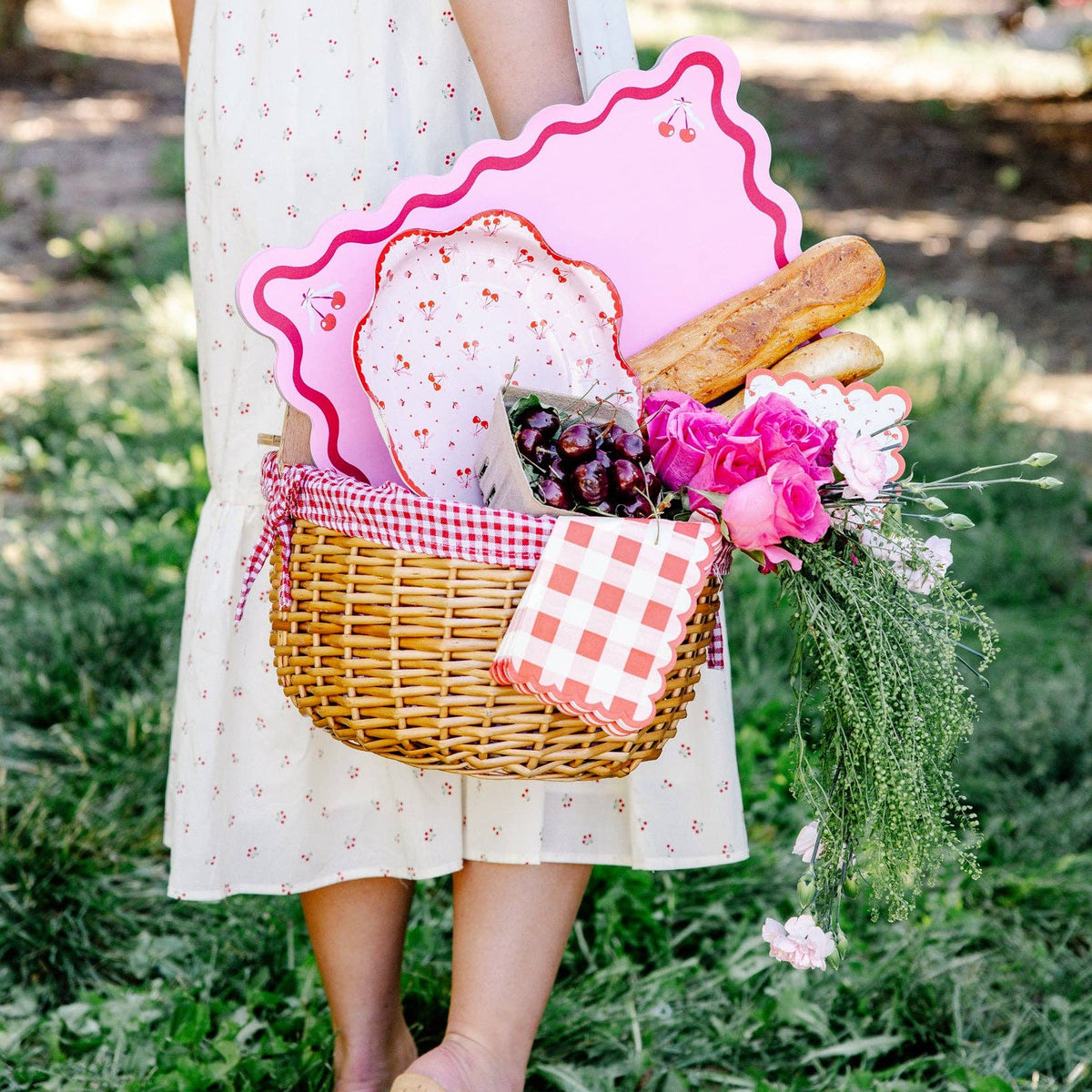 styled picnic basket display with cherry plates and pink decor
