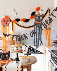 Halloween-themed decorations including a cat, pumpkin, and the 'Trick or Treat' banner with two bats on each end on a kitchen wall.