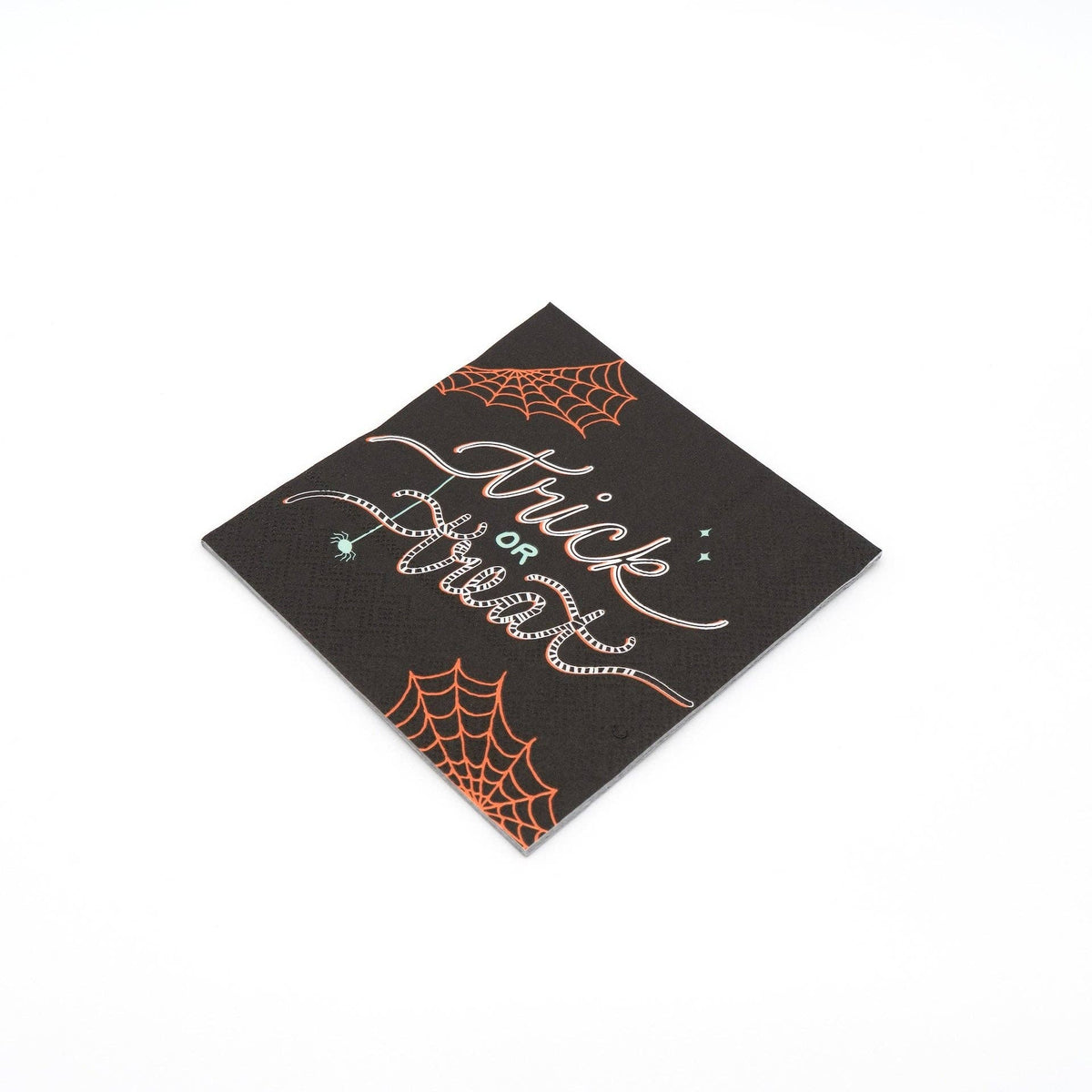 Single folded trick or treat cocktail napkin on a plain surface showing the black base, white script, and orange web detail.