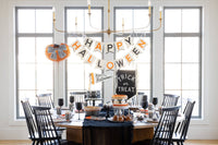 Halloween dessert table with the Trick or Treat felt banner, Happy Halloween banner, striped cups, black glassware and caramel apples