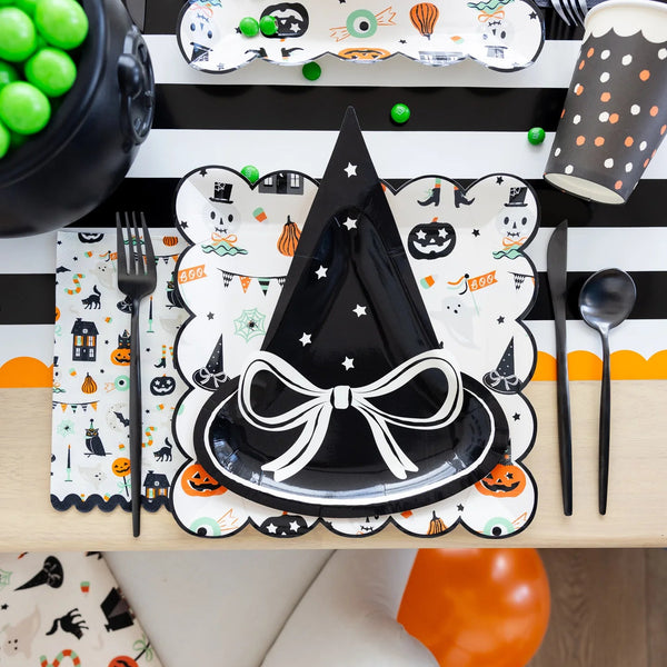 Close-up of place setting featuring witch hat plate on top of Tricks & Treats napkin