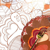 Angled view of the turkey coloring placemat showing the copper-foil outline and partially colored feathers.