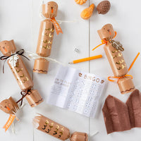 Flat lay of cracked open turkey crackers with dice, mini game, and tissue crown.