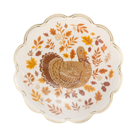 Angled view of the turkey foliage harvest plate showing the centered turkey, the circular fall-leaf wreath pattern, and the gold foil scalloped edge.