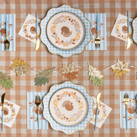 Preppy Thanksgiving table with turkey guest towels, turkey plates, gingham chargers and gold leaf garland