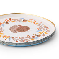 Angled stack of turkey Thanksgiving paper plates with a gold rim