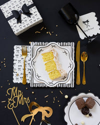 Tying the Knot cocktail napkin styled on a black and gold bachelorette party tablescape with cake slice
