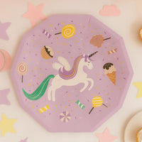 Close-up of a unicorn party plate on a white surface with star confetti