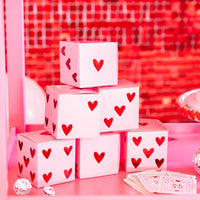 Group of heart dice treat boxes arranged with playing cards and party décor
