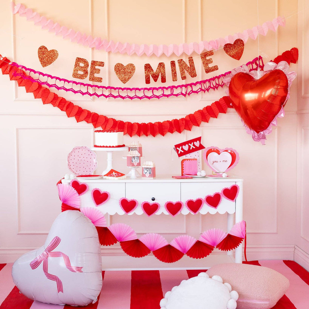 Valentine party setup featuring pink and red tissue bunting