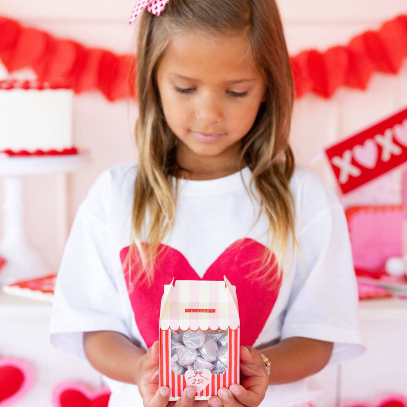 Child holding a Valentine kissing booth treat box filled with candy