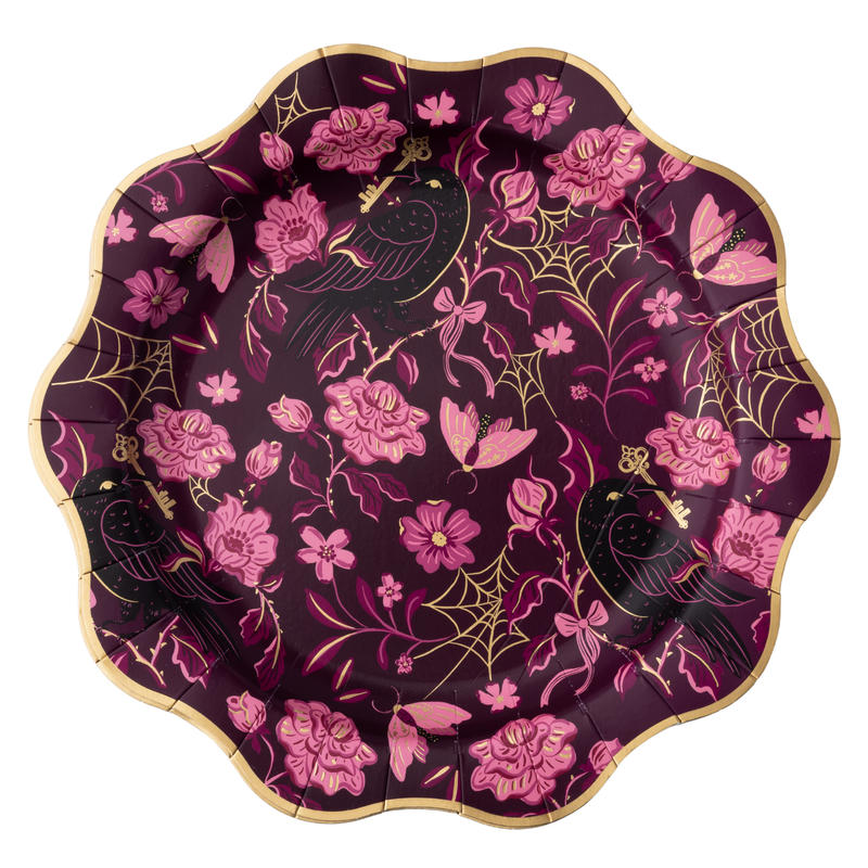 Plum gothic floral paper dinner plate with pink roses, black ravens, gold foil spiderwebs, and skeleton keys, with a scalloped gold foil rim, on a white background.