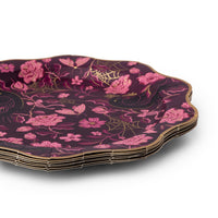 Stack of plum gothic floral paper dinner plates showing the scalloped gold foil edge and Victorian floral print with ravens and spiderwebs, on a white background.