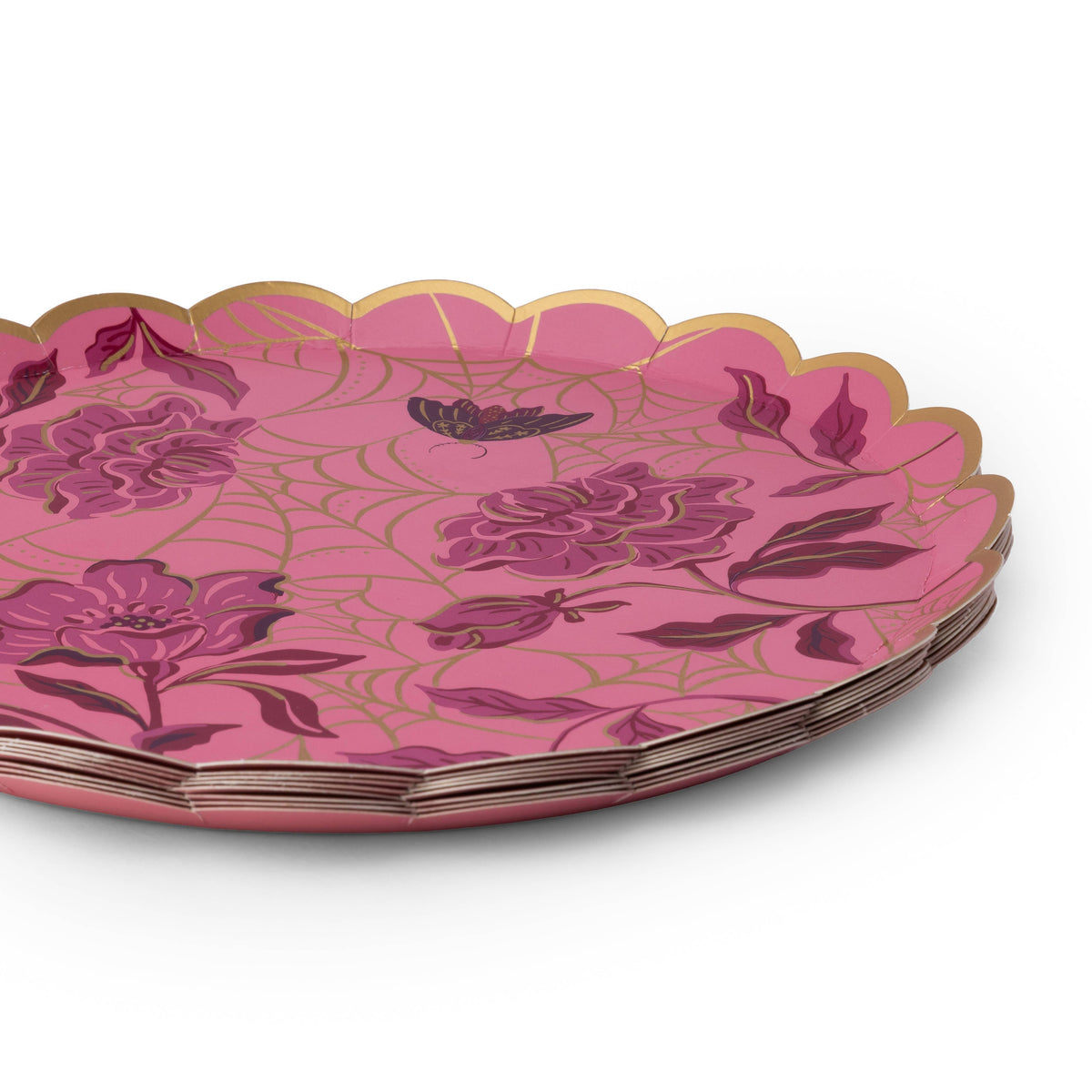 Stack of pink spider web paper cake plates showing the round scalloped gold foil edge and gold web print over fuchsia, on a white background.