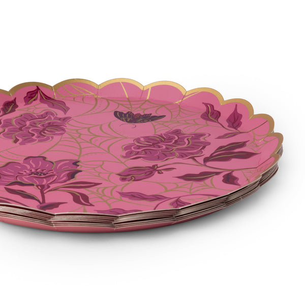 Stack of pink spider web paper cake plates showing the round scalloped gold foil edge and gold web print over fuchsia, on a white background.