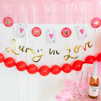 A Lucky in Love Party Sign and coin banner hung as a Vegas suite backdrop for a bachelorette weekend.