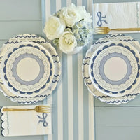 Blue bow napkins and plates styled with white roses and a blue striped runner
