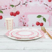 Cherry plate and matching cup on white wood with cherry blossom background