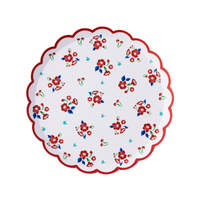 Single vintage floral scalloped paper dessert plate flat lay on white background showing full scattered red flower, blue leaf, and cherry print with red scalloped border