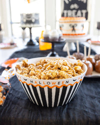 Vintage Halloween bamboo serving bowl filled with popcorn, and styled on a Halloween tablescape.