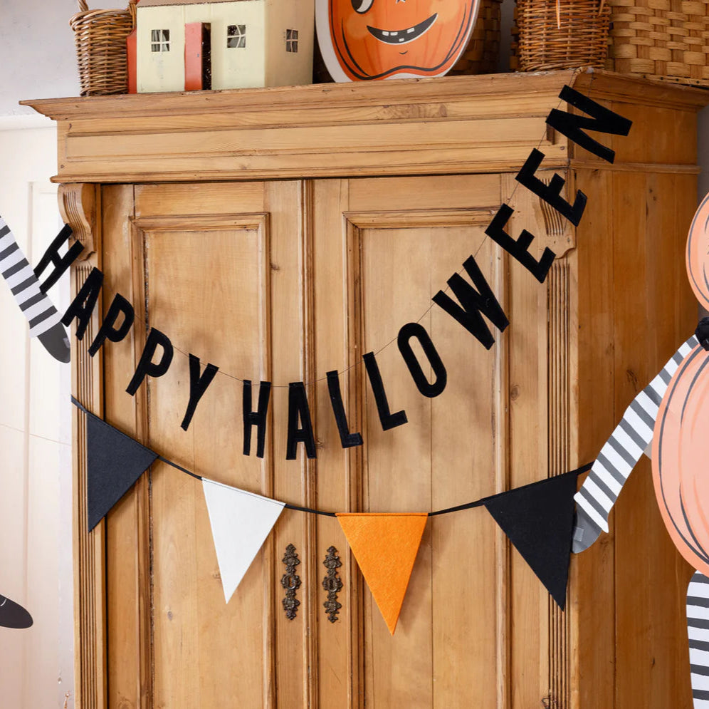 Felt pennant Halloween banner displayed with a Happy Halloween sign over a cabinet.