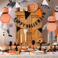 Halloween-themed table setting with decorations and pumpkins.