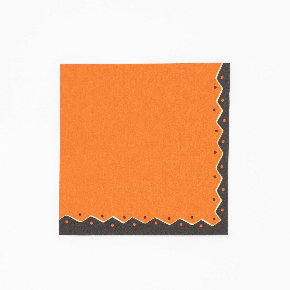 Vintage Halloween cocktail napkin in pumpkin orange with black and cream ric-rac dot detailing along the edges, flat view on white background.