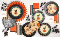 Flat lay of the vintage Halloween collection — cat plates, black rosette chargers, retro striped towels, paper fans, and orange napkins.