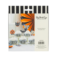Halloween-themed cupcake packaging with decorative toppers and liners on a black and white striped background.