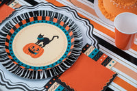 Styled Halloween table with the orange vintage napkins, black rosette plates, orange cups, and striped runner.