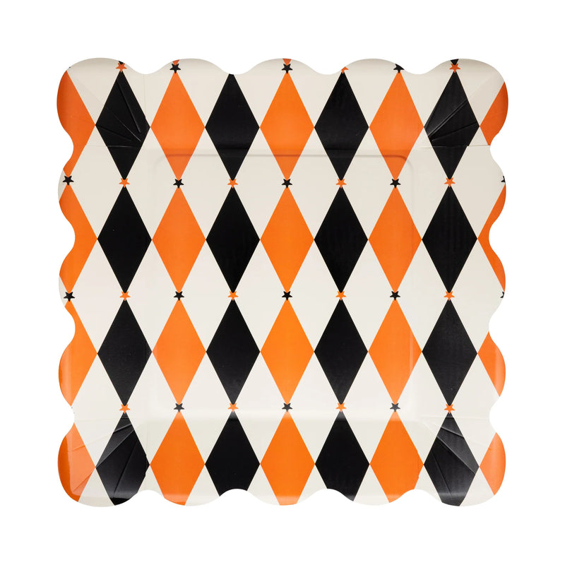 Single 11-inch square harlequin paper plate in orange, black, and cream with scalloped rim on white background.