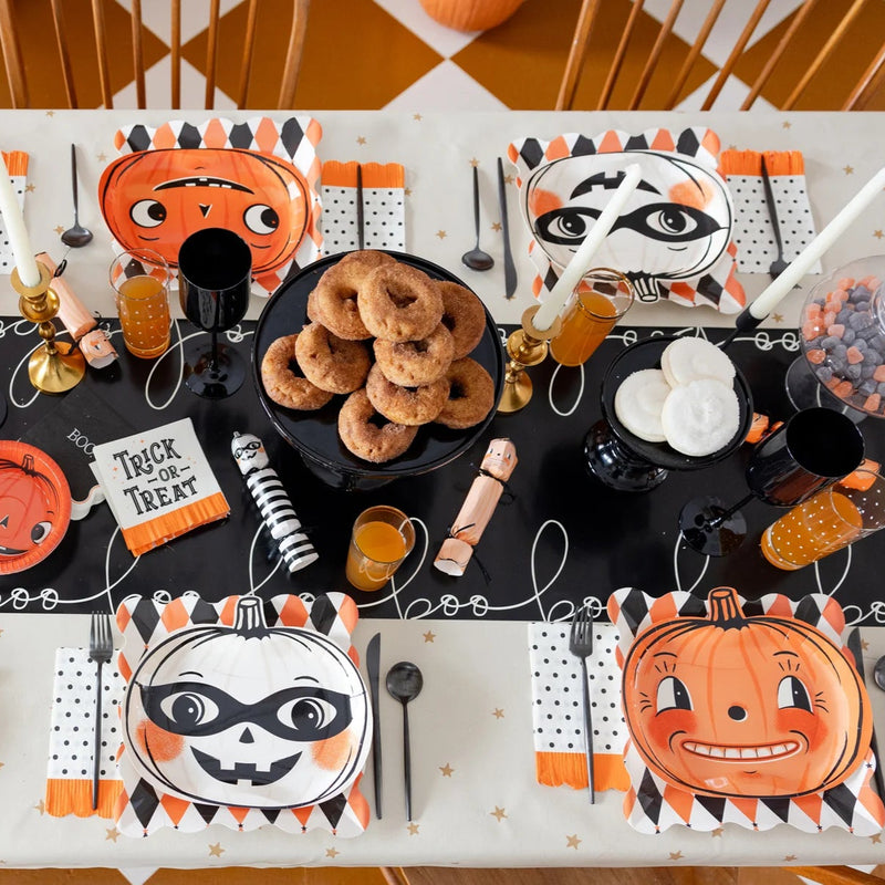 Overhead tablescape featuring three retro pumpkin designs from the Vintage Pumpkin Plate Set with coordinating napkins and runner.