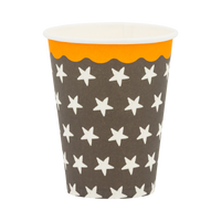 Black paper cup with a cream star pattern and orange scalloped rim, front view. 