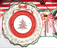 Overhead place setting featuring a vintage Christmas tree plate on a red die-cut scalloped charger with gold flatware.