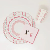 Overhead view of a stork napkin and stacked plates on a white surface