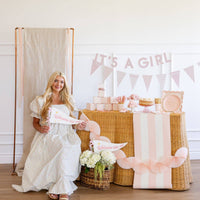 Baby shower setup featuring welcome little one pink pennant and soft pink decor
