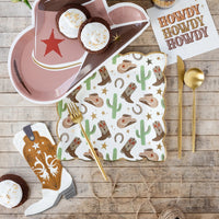 Boot napkin on dessert table with hat plate and cactus print—fun western party decorations.