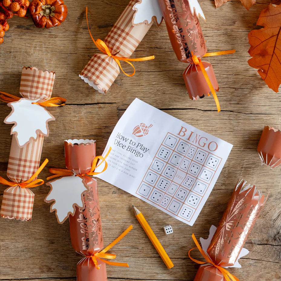 Flat lay of opened wheat crackers revealing a die, mini game sheet, and tissue crown.
