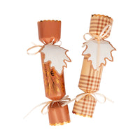 Two assembled wheat party crackers in a row with attached tags.