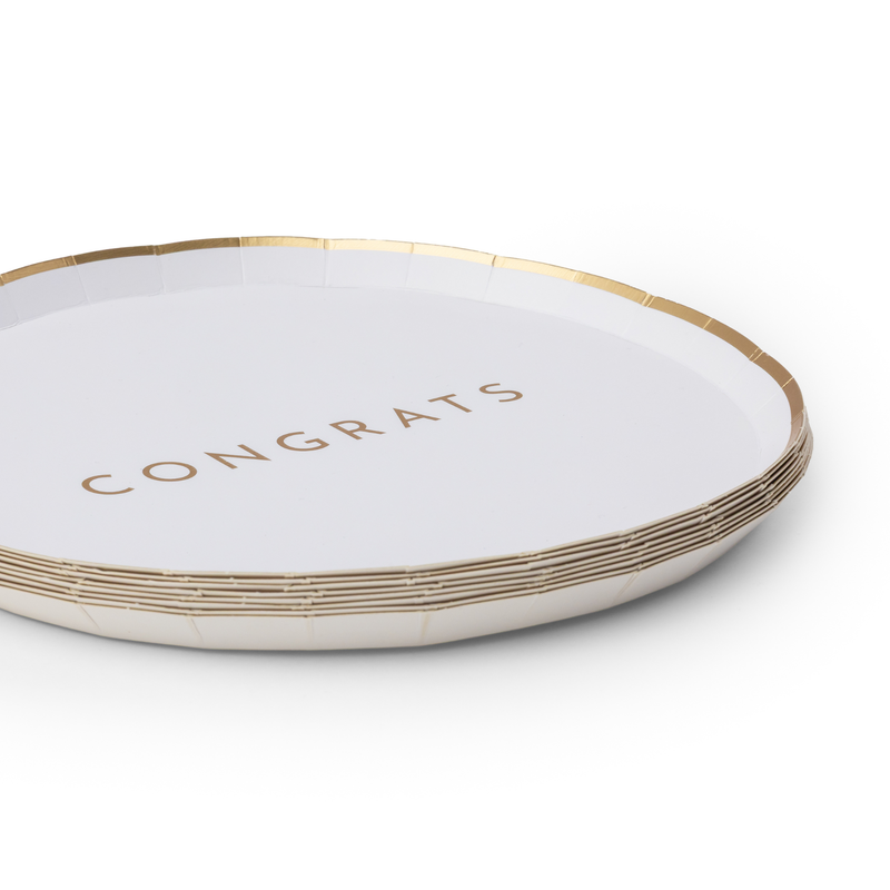 Angled stack of white Congrats plates showing the gold-foil lettering, thin gold rim, and the full set depth.