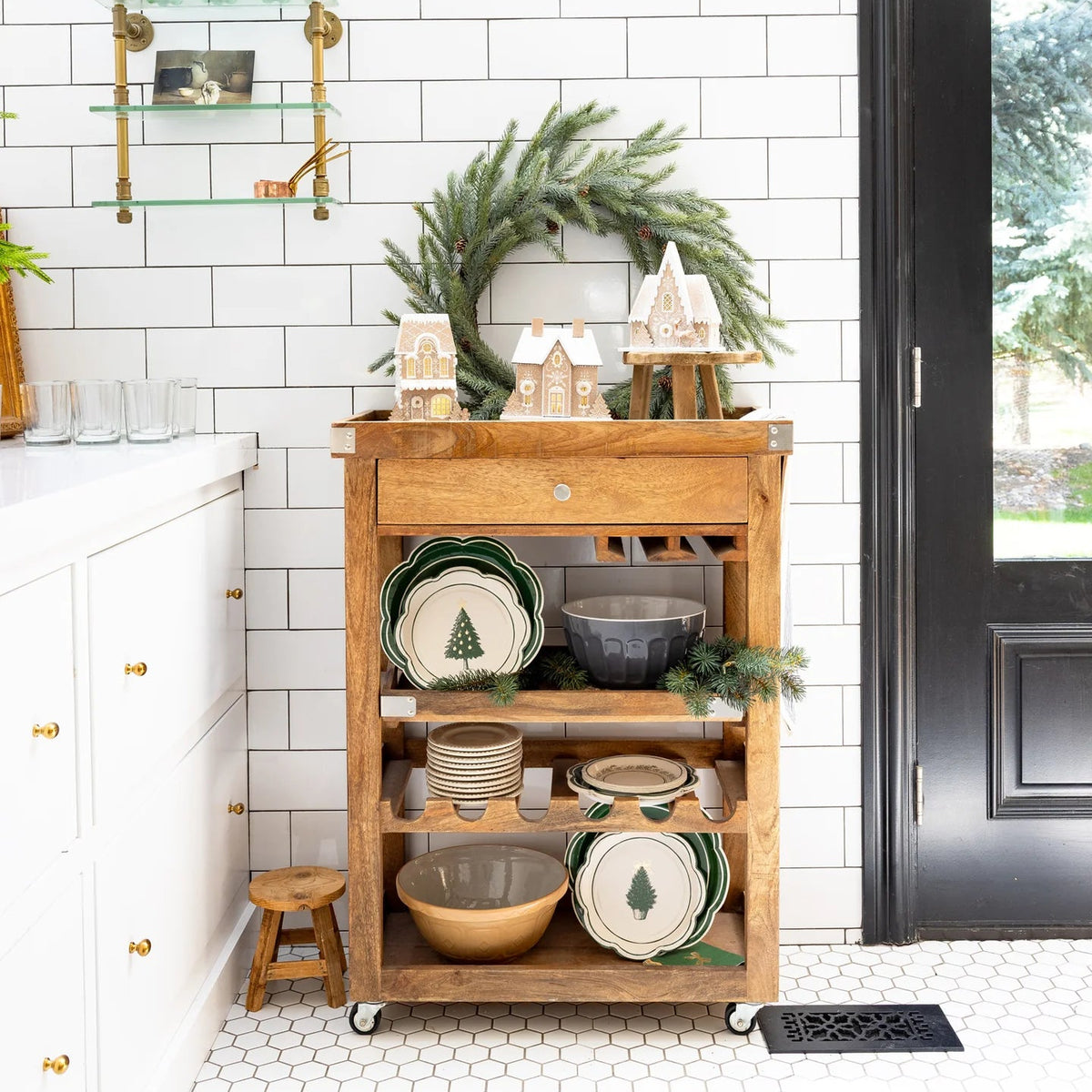 Wide view of a kitchen bar cart displaying the complete gingerbread house collection, highlighting the A-frame Christmas house design.