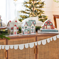 Wide shot of the entire Christmas village collection set up on a console table, featuring the Reindeer Barn decor prominently on the right.