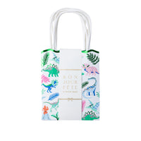 Wild Dinosaur favor bag with colorful dinos, palm leaves, a green scalloped top, and handles