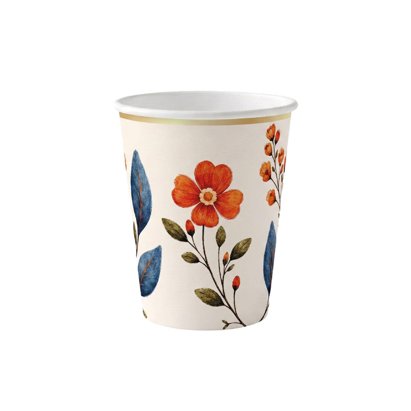 Cream paper party cup with painted wildflower stems, blue leaves, and a gold rim on a white background