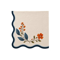 Cream cocktail napkin with a navy wavy edge and painted wildflower stem in rust and blue