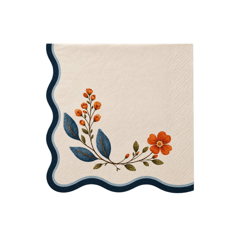 Cream cocktail napkin with a navy wavy edge and painted wildflower stem in rust and blue